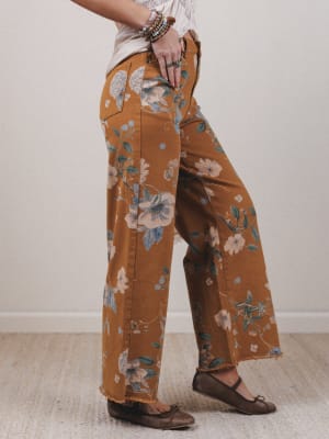 Person wearing brown floral pants on a plain background