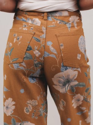 Brown floral-patterned pants worn by a person on a plain background