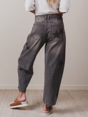 Person wearing dark gray pants and white shirt on a plain background