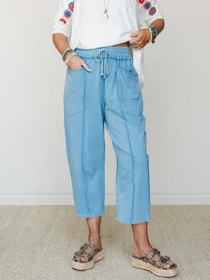 Light-wash barrel-leg pants with a relaxed, lived-in feel styled with a crochet-embroidered white top and leopard espadrille sandals — the kind of outfit that looks effortless but clearly wasn't an accident.