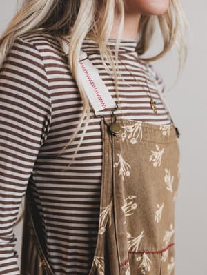 Person wearing a striped shirt and a brown skirt with floral pattern