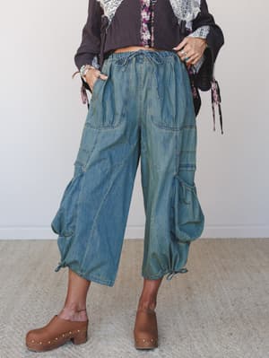 Wide-leg denim cargo pants in a worn-in dirty denim wash, styled with a layered boho top and wood-studded clogs — the kind of outfit that looks effortless but was absolutely thought about.