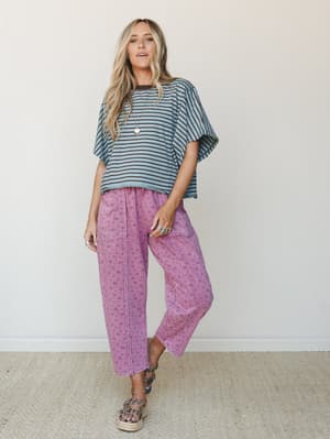 A breezy, mix-print outfit pairing an oversized striped tee with acid-washed floral cargo pants in magenta — the kind of effortless combo that looks like it came together on a good-hair day.