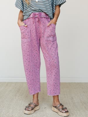 Relaxed-fit magenta pants with an all-over ditsy floral print and smocked drawstring waist, styled with a blue striped top and platform espadrille sandals for an effortlessly playful everyday look.