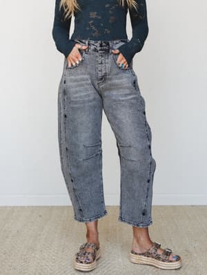 Acid-washed black denim wide-leg pants styled with a dark teal lace-knit long-sleeve top and leopard print platform espadrille sandals — the kind of outfit that looks effortless but is clearly very thought out.
