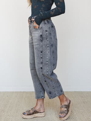 A side-profile shot of acid-washed black denim wide-leg pants styled with a dark teal crochet long-sleeve top and leopard print platform sandals — the kind of outfit that looks effortless but definitely took three tries.