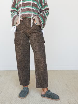Leopard-print barrel cargo pants styled with a striped knit pullover and slate suede mules — the kind of outfit that looks effortless but definitely took some thought.