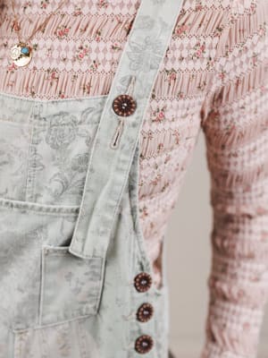 Close-up of a light denim jacket with floral patterns in the background
