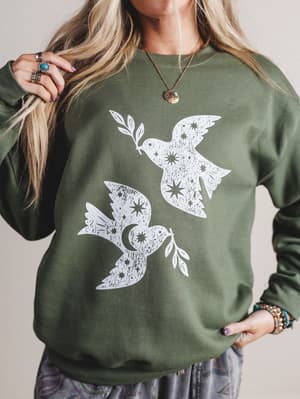 Green sweatshirt with white dove designs worn by a person.