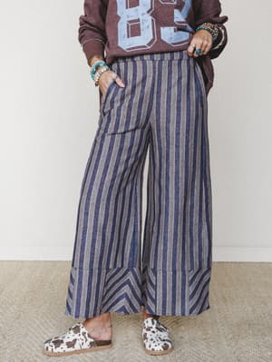 Wide-leg striped pants styled with a vintage graphic sweatshirt and cow-print slides — the kind of effortlessly eclectic combo that looks like it took zero effort and actually took all the right instincts.
