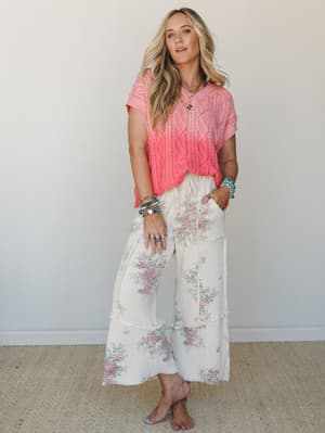 A breezy, feel-good outfit pairing a coral ombre cable-knit sweater top with wide-leg floral waffle pants — the kind of look that makes a casual afternoon feel a little more like a daydream.