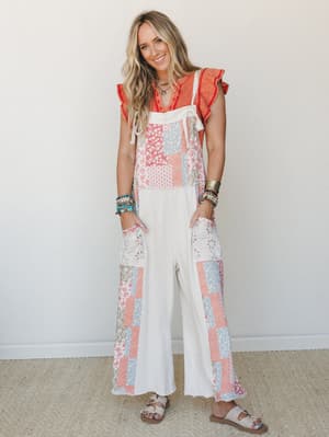 A wide-leg patchwork jumpsuit in cream and ecru layered over a coral ruffle-sleeve top — the kind of outfit that looks like it was effortlessly thrown together but definitely wasn't.