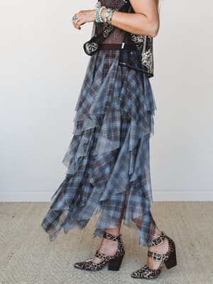 A tiered plaid maxi skirt in sheer, floaty layers styled with a sequin embellished vest, turquoise stacked bracelets, and leopard print block heels — the kind of outfit that has a whole personality.