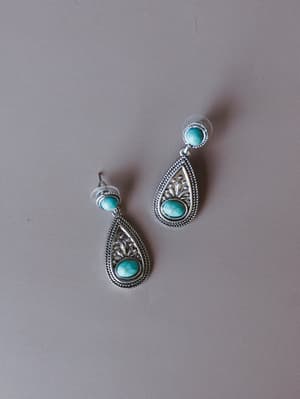 A pair of silver teardrop drop earrings with turquoise stone settings — the kind of piece that quietly anchors a whole outfit with that effortless Western-meets-boho energy.