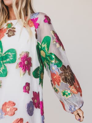 Colorful floral embroidery on a sheer fabric with a plain background