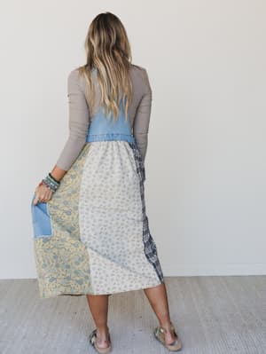 Woman wearing a patchwork skirt with a plain background