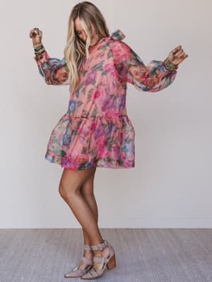 Woman wearing a floral dress against a plain background