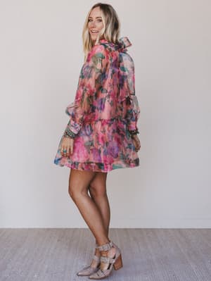 Woman wearing a floral dress against a plain background