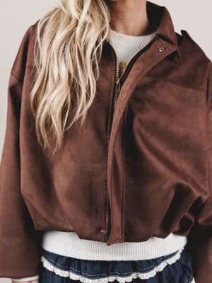 Brown jacket worn by a person with blonde hair, on a plain background