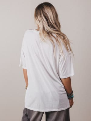 Person wearing a white oversized t-shirt against a plain background
