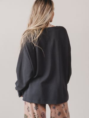 Person wearing a black oversized sweatshirt with a neutral background
