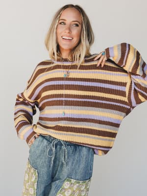 Person wearing a striped sweater with a neutral background