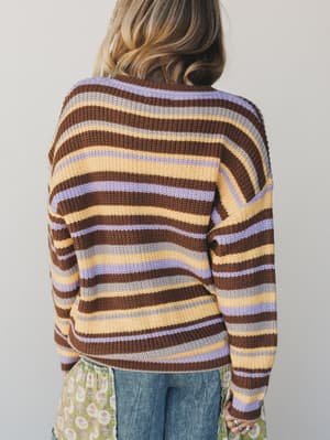 Person wearing a striped sweater with a neutral background