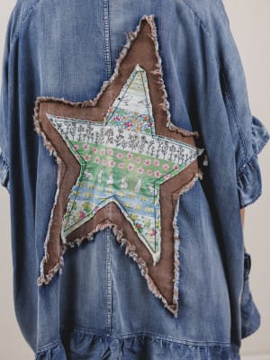 Blue denim jacket with a star-shaped patch featuring a floral design.