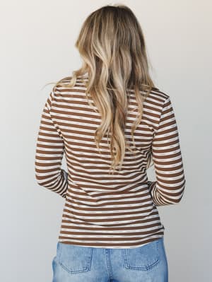 A back-view shot of a fitted long-sleeve striped top in warm mocha and cream, paired with light wash denim — the kind of effortless layering piece that works as hard as you do on a Tuesday.