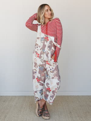 A relaxed, full-length floral and cow-print patchwork overall paired with a red striped long-sleeve hoodie — the kind of outfit that somehow makes total sense and feels like your most comfortable, expressive self.