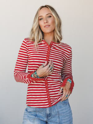 A red and cream striped henley top styled with stacked turquoise bracelets and silver rings — the kind of effortless, accessory-heavy look that feels just as at home on a weekend errand run as it does at a backyard gathering.