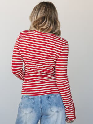 A back-facing shot of a red and cream striped long-sleeve top paired with light wash jeans — easy, classic, and the kind of top that goes with everything without trying too hard.