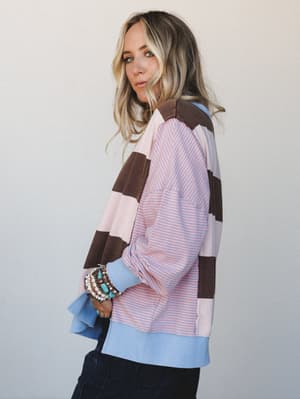 A side-profile shot of a model in a relaxed, colorblock patchwork top with mixed stripe and solid panels — the kind of piece that looks like it was made from your favorite vintage finds, styled with stacked turquoise and pearl bracelets for that effo
