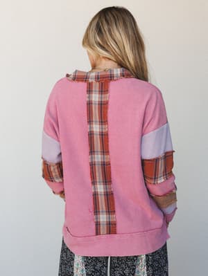 Shot from the back, this patchwork thermal top in bubblegum pink mixes waffle knit with raw-edge plaid panels down the center back and along the sleeves — the kind of top that looks like it came from someone's very cool vintage collection.