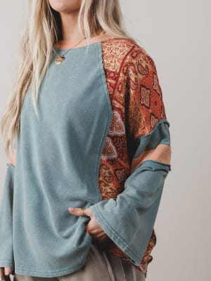 Light blue long-sleeve top with patterned sleeves worn by a person.