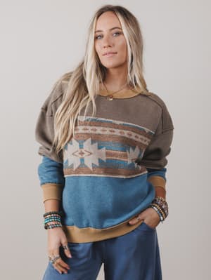 Woman wearing a patterned sweater with a neutral background