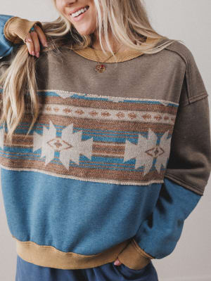 Person wearing a patterned sweater with a neutral background