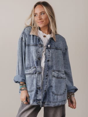 Woman wearing a denim jacket on a plain background