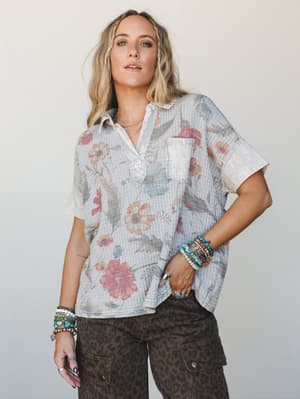 A relaxed floral waffle-knit top with a vintage-washed feel, styled with leopard print cargo pants and stacked turquoise and beaded bracelets — the kind of outfit that looks effortless but was absolutely thought about.