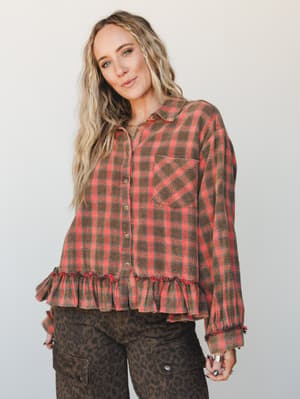 A plaid flannel button-down top with a playful ruffle hem gets an unexpected boho twist, styled with leopard print cargo pants for an earthy, lived-in look that feels like fall dressing done right.