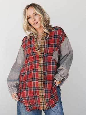 A mixed-fabric oversized flannel button-down in bold red plaid with contrasting grey corduroy sleeves and raw frayed hem — the kind of top that looks like it's been living in someone's closet for years in the best way.