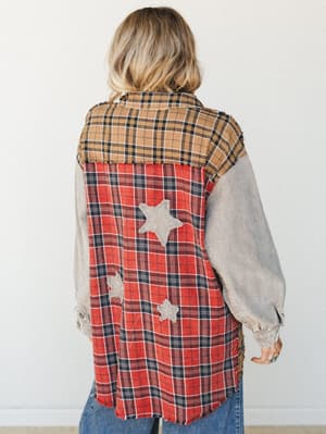A patchwork flannel shacket shot from the back, mixing red and tan plaid panels with washed gray sleeves and hand-stitched star appliqués — the kind of piece that looks like it has a whole story behind it.
