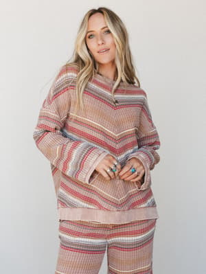 A relaxed waffle-knit striped pullover top styled as a matching set with wide-leg pants, worn with layered silver and turquoise rings — the kind of outfit that feels like a cozy day off done really, really well.