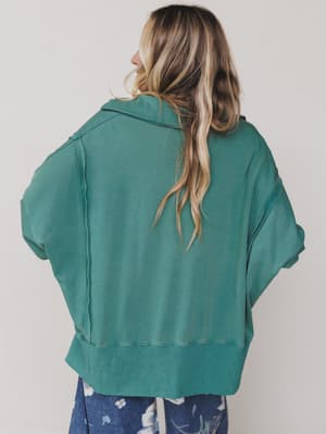 Green / Person wearing a teal jacket from behind on a plain background