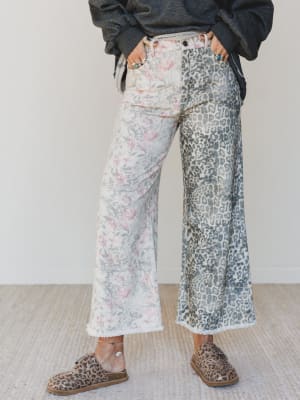 Person wearing floral and leopard print pants with a plain background