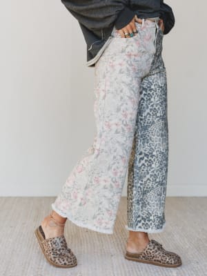 Person wearing floral and leopard print pants with a neutral background