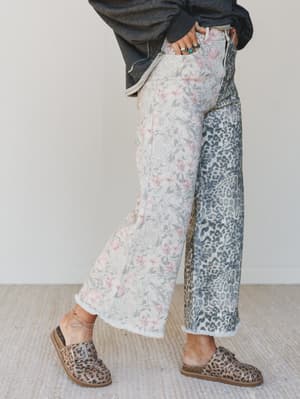 Person wearing floral and leopard print pants with a plain background