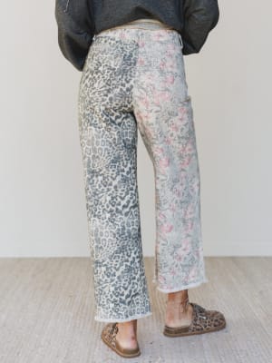 Person wearing floral and leopard print pants on a plain background