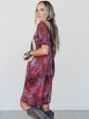 Woman wearing a tie-dye dress with a plain background