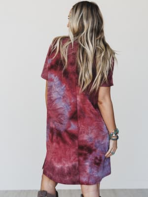 Person wearing a tie-dye dress with a plain background